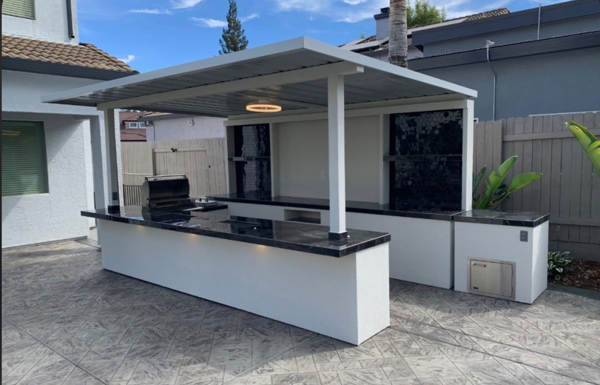 White stucco entertainment cabana with black hex tile, Lion grill and covered seating bar