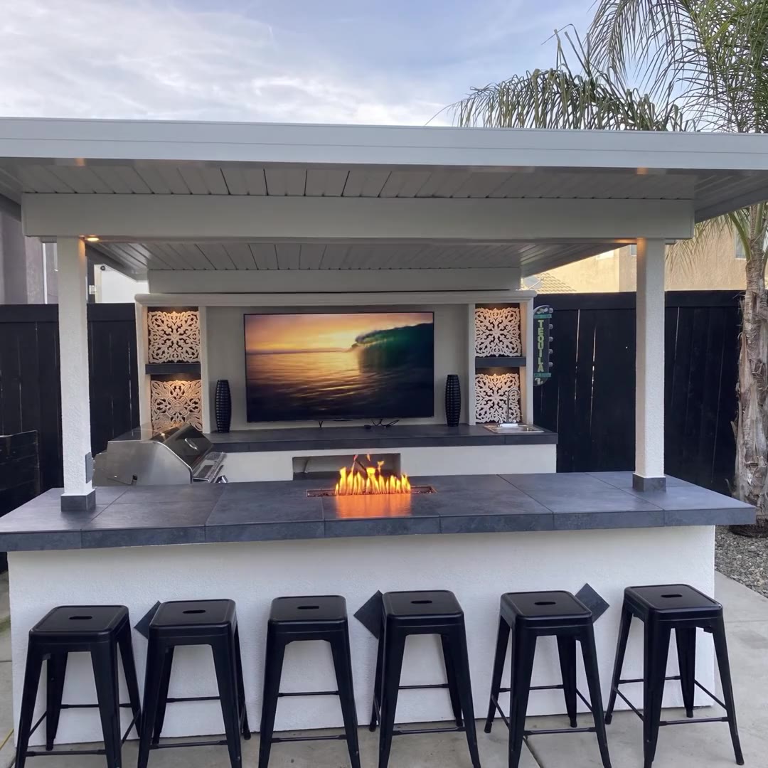 Covered entertainment cabana with TV wall, fire feature and six bar stools